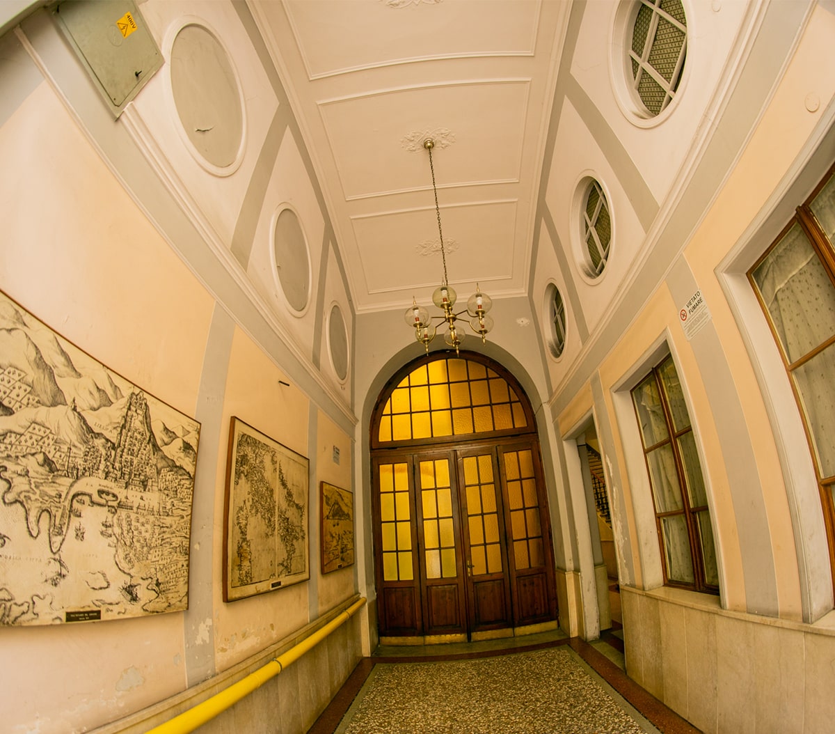 Ingresso monumentale con volta affrescata, lampadario d'epoca e mappe alle pareti