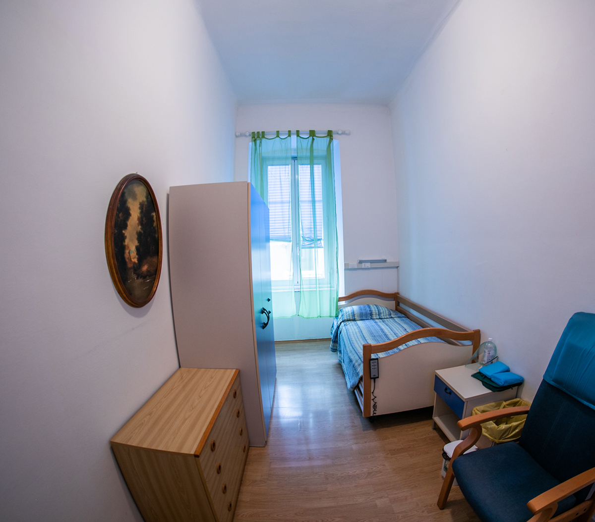 Camera singola con letto regolabile e tende luminose